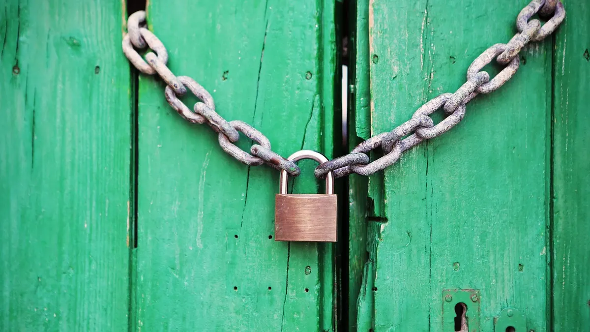 Cadeado com corrente em porta de madeira verde