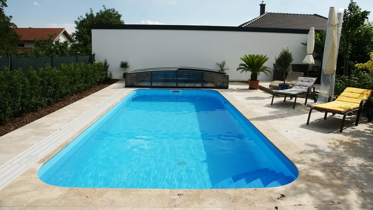 Piscina de fibra azul em quintal com espreguiçadeiras